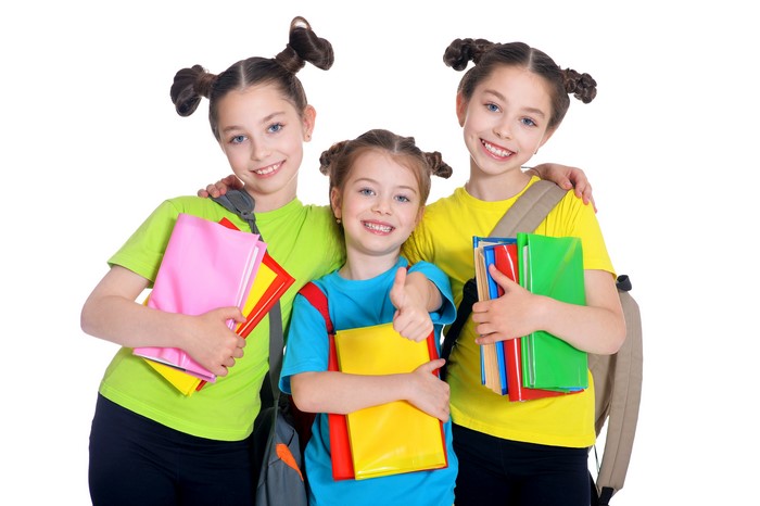 Three little girls with books and backpacks
