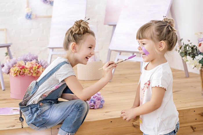 Two little girls painting faces