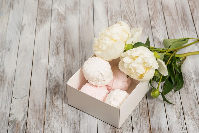 White peonies and pink and white zefir in a box