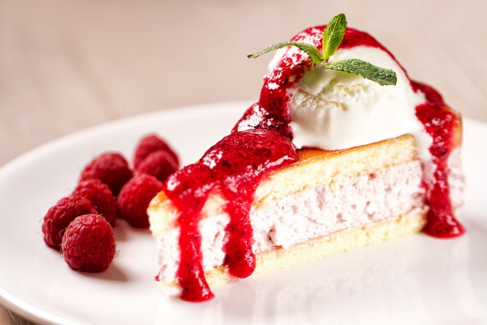 Slice of cake with ice cream and raspberries