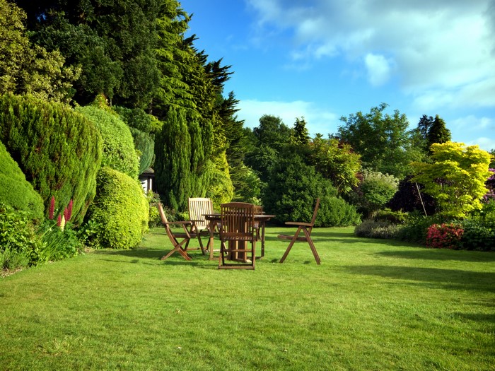 Garden with wooden table and chairs on lawn