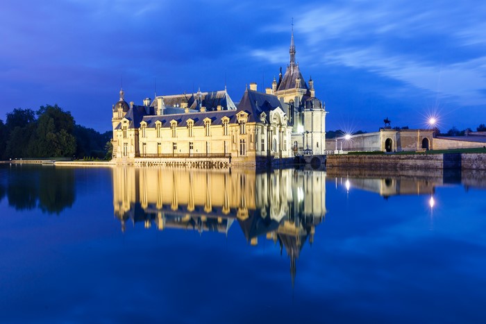 Chantilly Castle reflected in pond at night