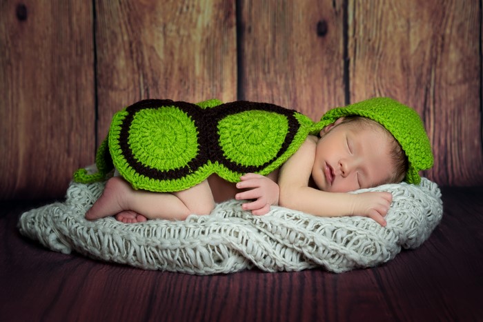 Newborn baby sleeping in a turtle costume