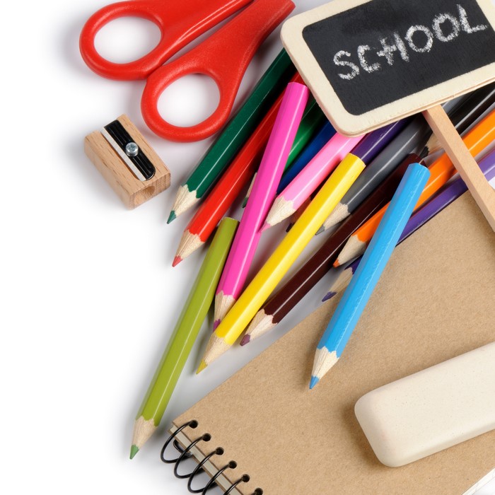School supplies: pencils, scissors, sharpener, eraser, notebook, and chalkboard sign