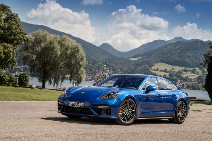 Blue Porsche Panamera Turbo parked by a lake