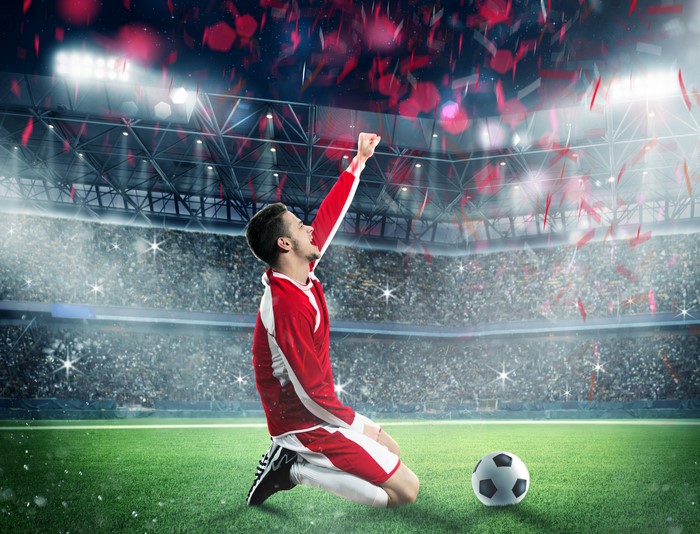 Soccer player celebrating in a stadium with confetti
