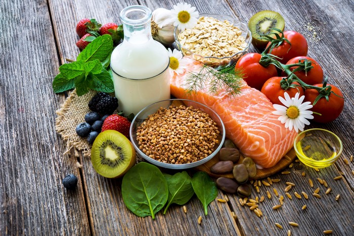 Still life of salmon, fruits, vegetables, grains, and milk