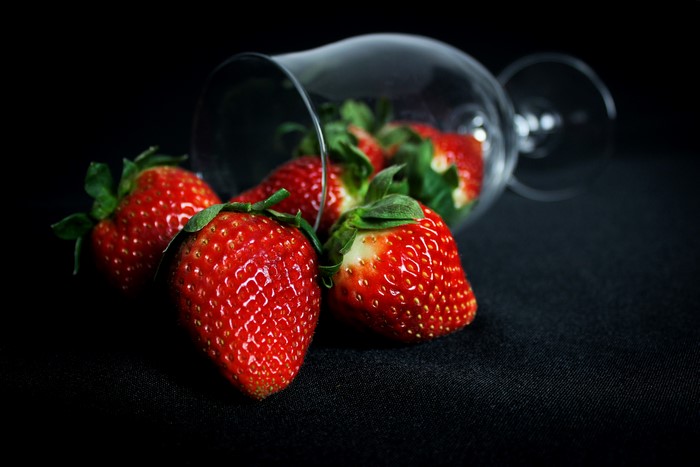 Strawberries spilling from a shot glass