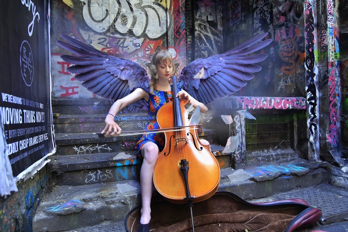 Angel playing cello in graffiti alley
