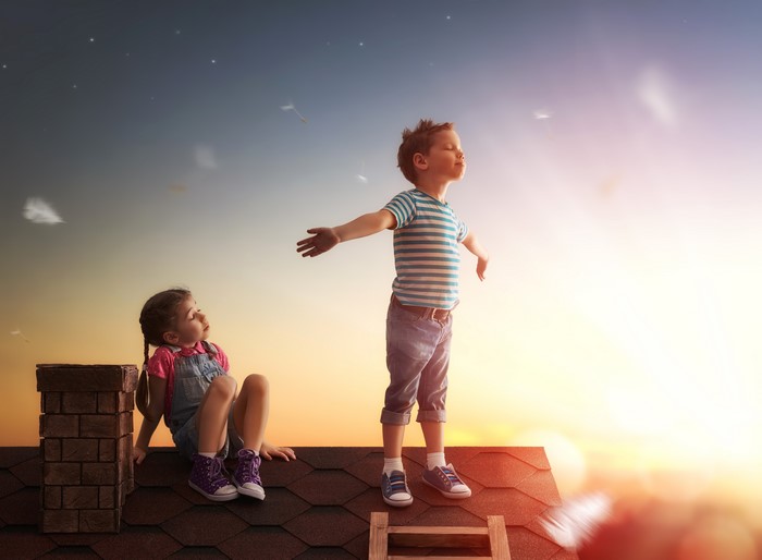 Children on a rooftop at sunset