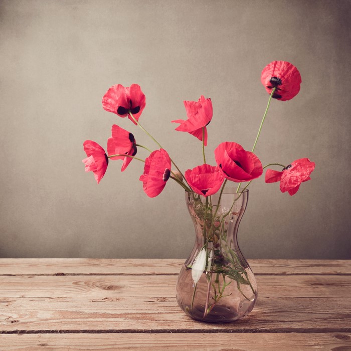 Red Poppies in a Glass Vase on a Wooden Table