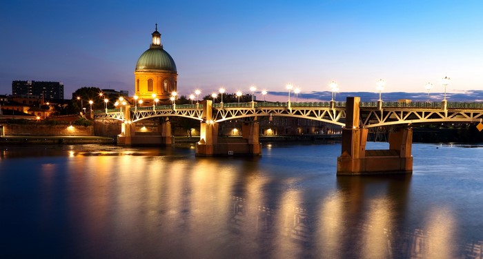 Pont Neuf bridge and dome at night in Toulouse, France