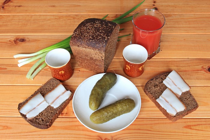 Still-life with bread, cucumbers, salo, juice, and green onions