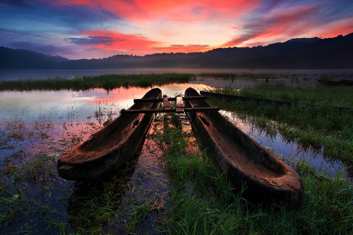 Two wooden boats on Tamblingan Lake at sunrise, Bali, Indonesia