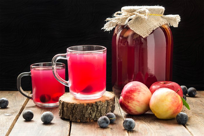 Two cups of plum juice with apples and plums