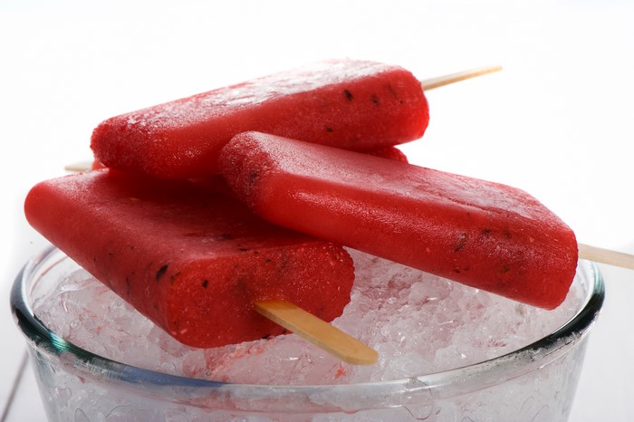 Three red popsicles on ice