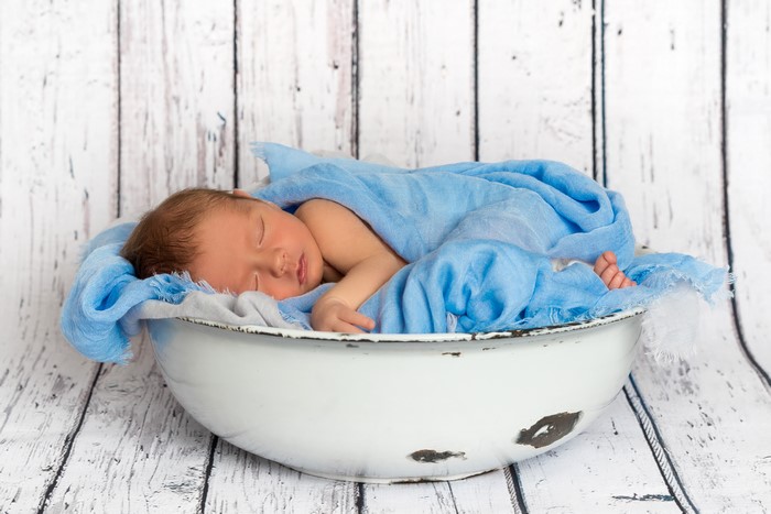 Newborn baby sleeping in a bowl