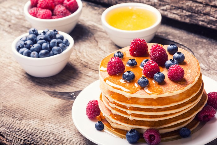 Pancake stack with raspberries, blueberries, and honey