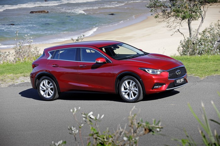 Red Infiniti Q30 1.6t parked by the beach