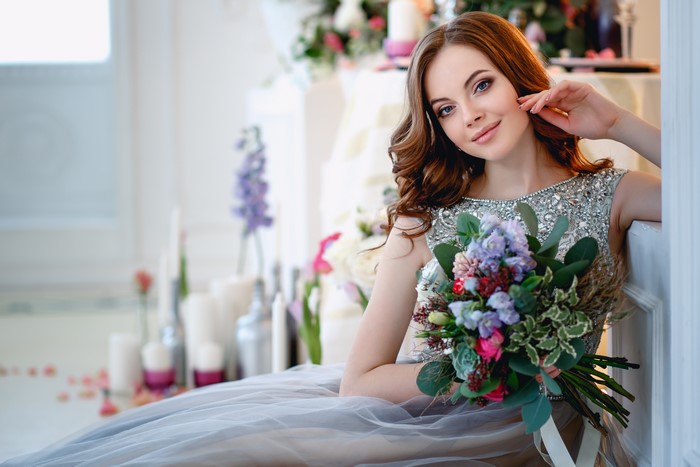 Woman with bouquet in a grey dress