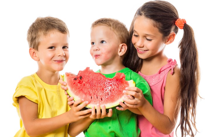 Three children sharing a slice of watermelon