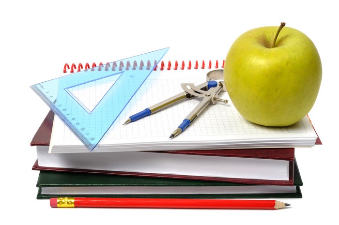 School supplies with apple on white background