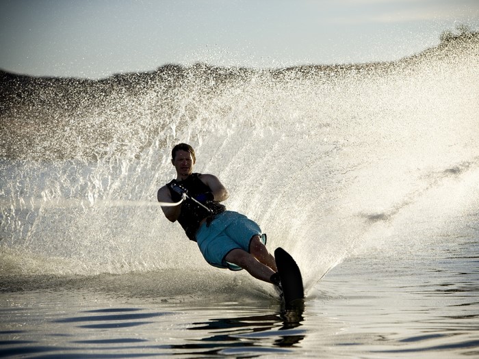 Man water skiing creating a large splash