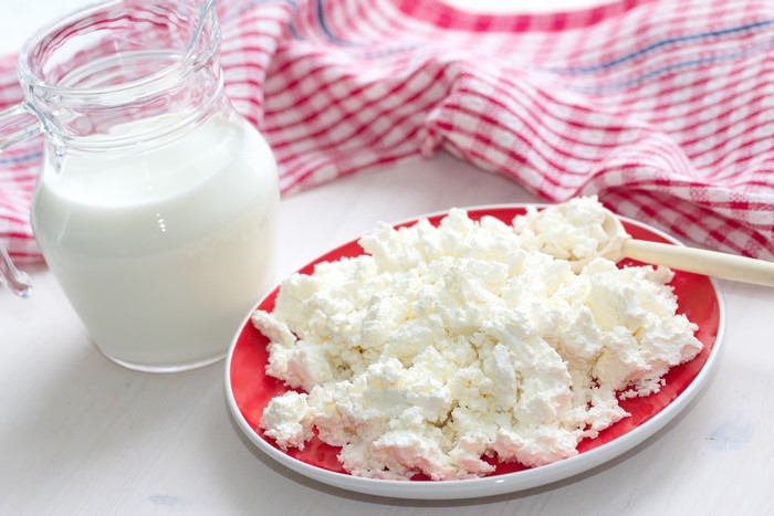 Milk in a jug and cottage cheese on a plate