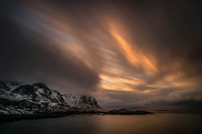 Long exposure of clouds over snowy mountains in Lofoten, Norway