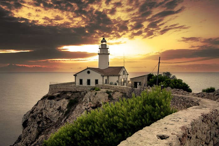 Lighthouse on a cliff at sunset, Cala Ratjada, Spain