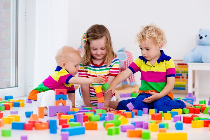 Three Children Playing with Colorful Blocks