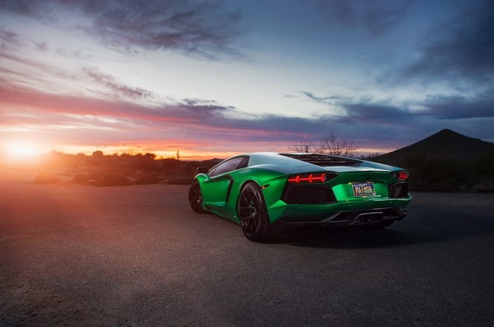Green Lamborghini Aventador back view at sunset