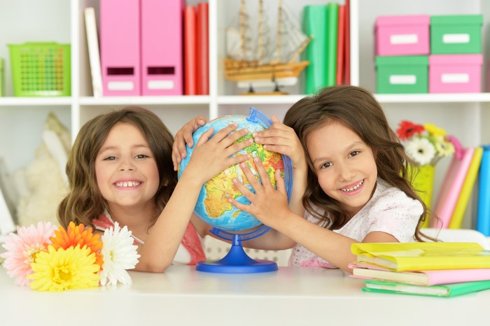 Two little girls holding a globe