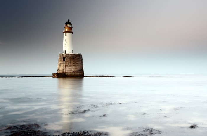 Lighthouse on a stone base in the sea