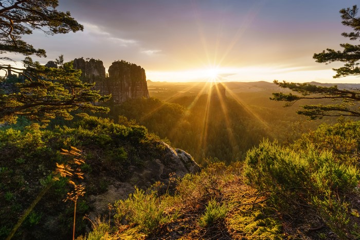 Sunrise over rocky mountains with sun rays