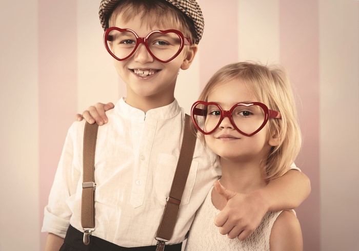 Boy and girl wearing heart-shaped glasses