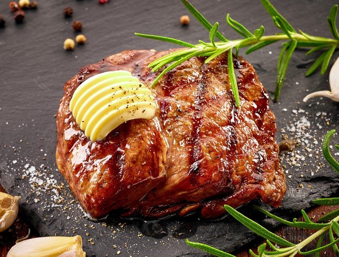 Grilled steak with butter and rosemary