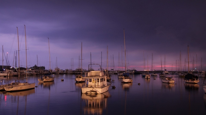 Boats docked in a harbor at dusk