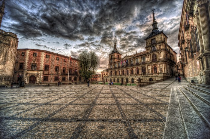 Plaza in Toledo, Spain with historic buildings and cloudy sky