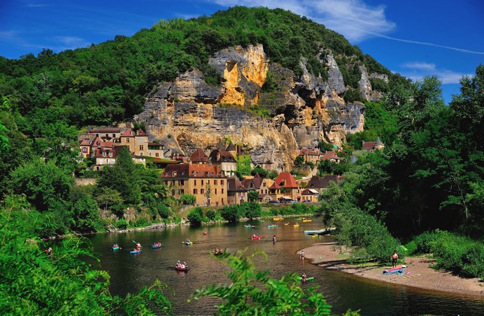 Village nestled in a cliffside by a river in France