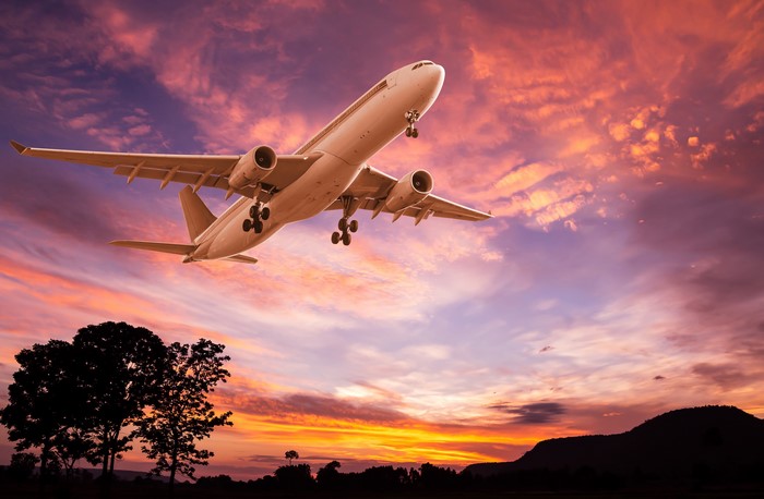 Airplane flying at sunset