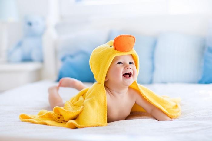 Baby in a yellow duck towel smiling