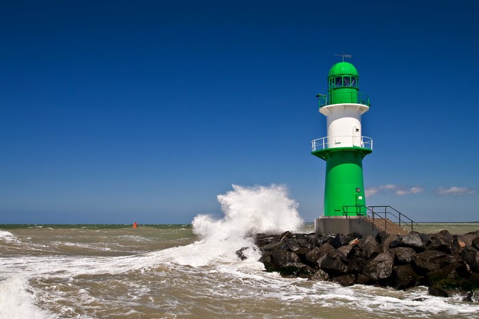 Lighthouse at Rostock Warnemunde with waves crashing