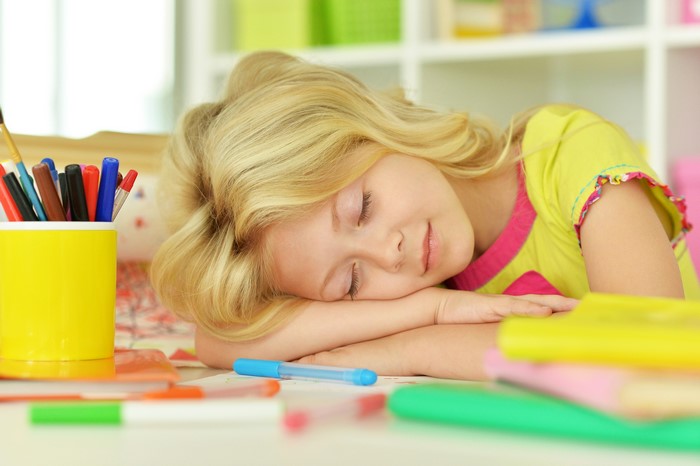 Blonde girl sleeping at a desk
