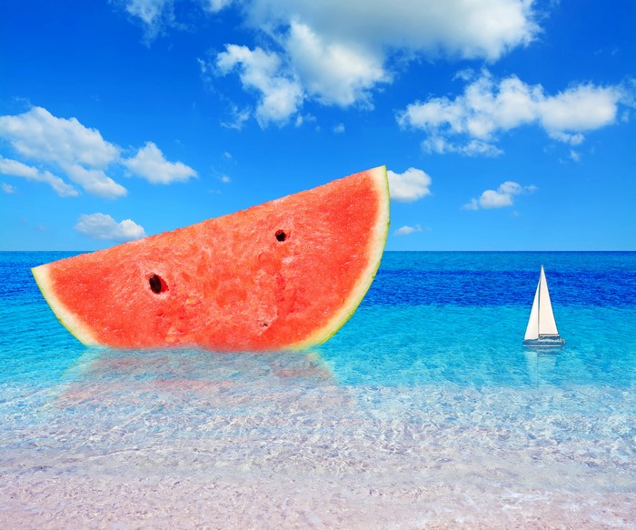Slice of watermelon in the sea with sailboat