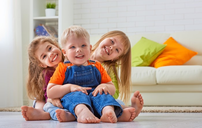Three Children Smiling on the Floor