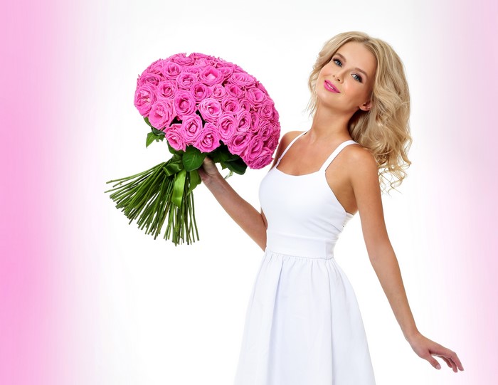 Blonde girl with a bouquet of pink roses