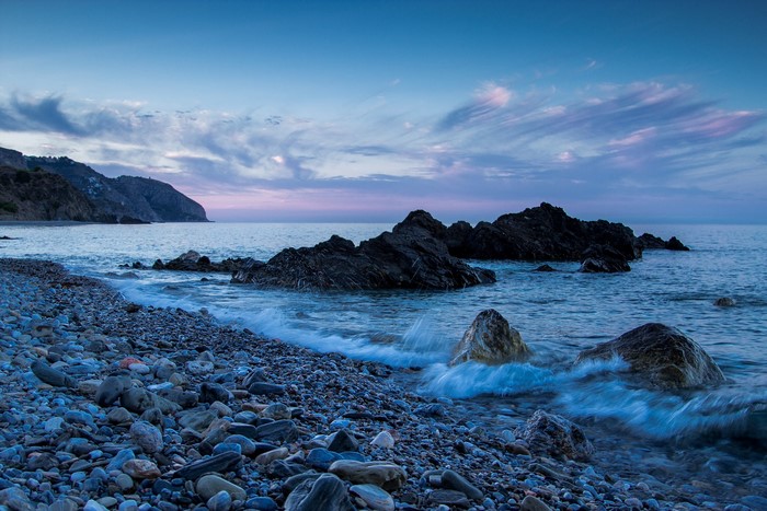 Rocky beach and sea at dusk, Andalusia, Spain