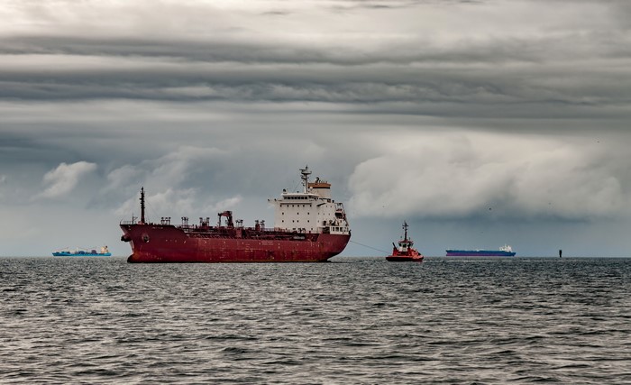Tanker ship being towed by a tugboat on the sea