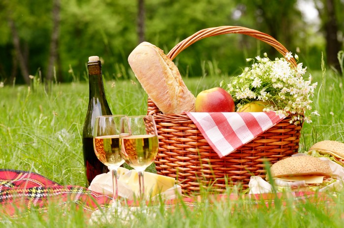 Picnic with wine, bread, and sandwiches in grass